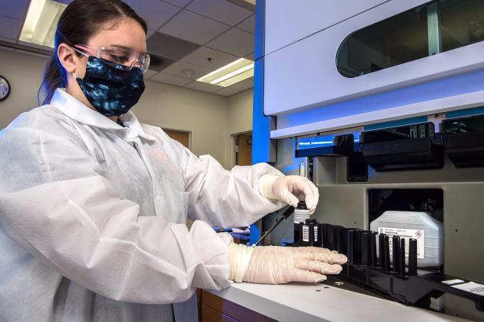 Centers for Disease Control and Prevention (CDC) scientist was preparing a laboratory instrument, used to conduct SARS-CoV-2 diagnostic testing.